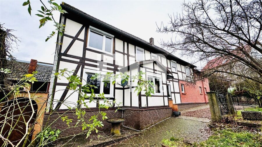 Ein- bis Zweifamilienhaus mit Anbau und Nebengebäude auf großem Grundstück - Seitenansicht